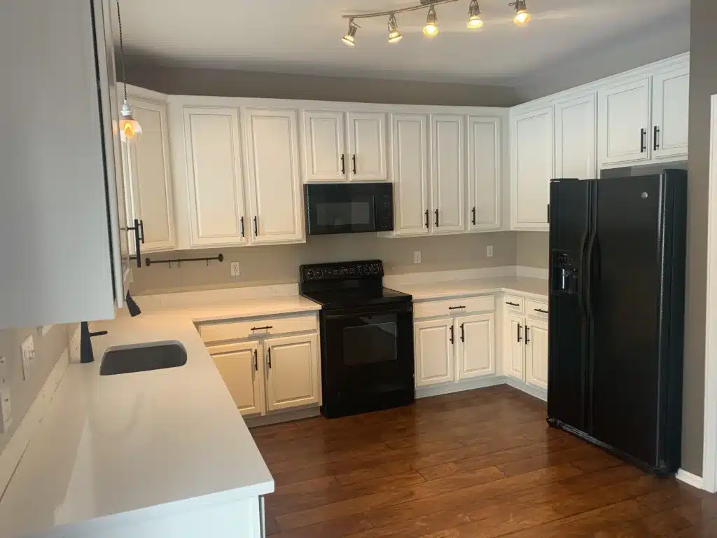 Professional Bathroom Interior Painting Services A clean bathroom with light beige walls, a toilet, vanity, and a colorful shower curtain, showcasing fresh interior paint.